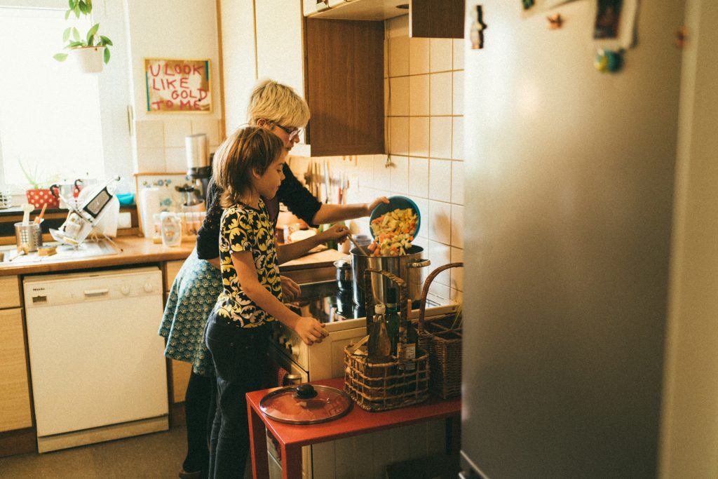 Eine Mütterpflegerin kennt sich mit gesunder Familienernährung aus und bezieht auch Geschwisterkinder spielerisch ins Kochen mit ein.